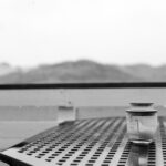 Foto eines Terrassentisches mit Windlichtern bei Regen