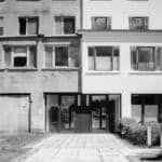Schwarz-Weiß Foto eines Hauseinganges in Prora, bei dem nur eine Seite erneuert wurde