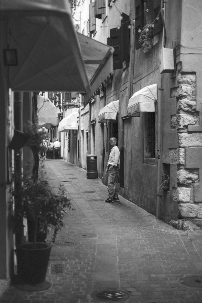 Schwarz-Weiß Foto mit einer Frau in einer engen Gasse in Garda am Gardasee