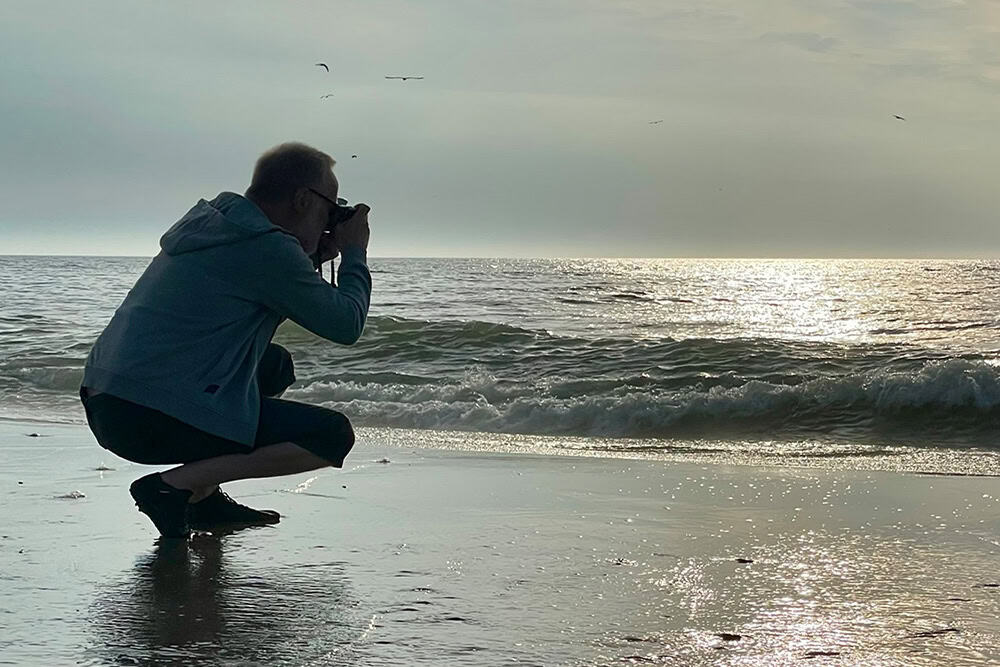 Das Foto zeigt mich beim Fotografieren an der Nordsee