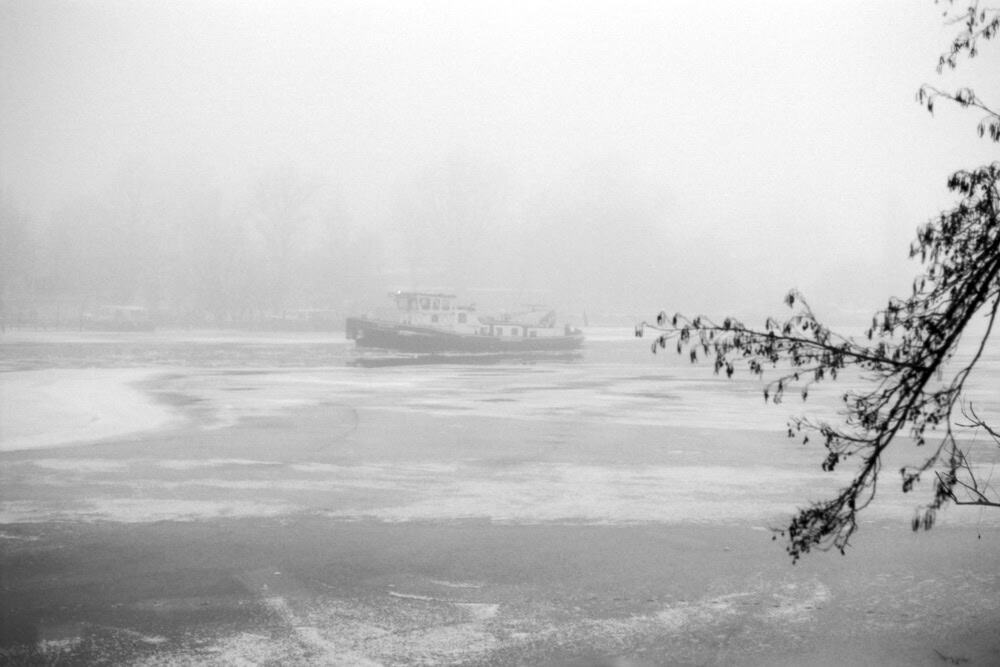 Dieses Schwarz-Weiß-Foto zeigt einen Eisbrecher, der im Winter auf der Havel in Potsdam fährt. 