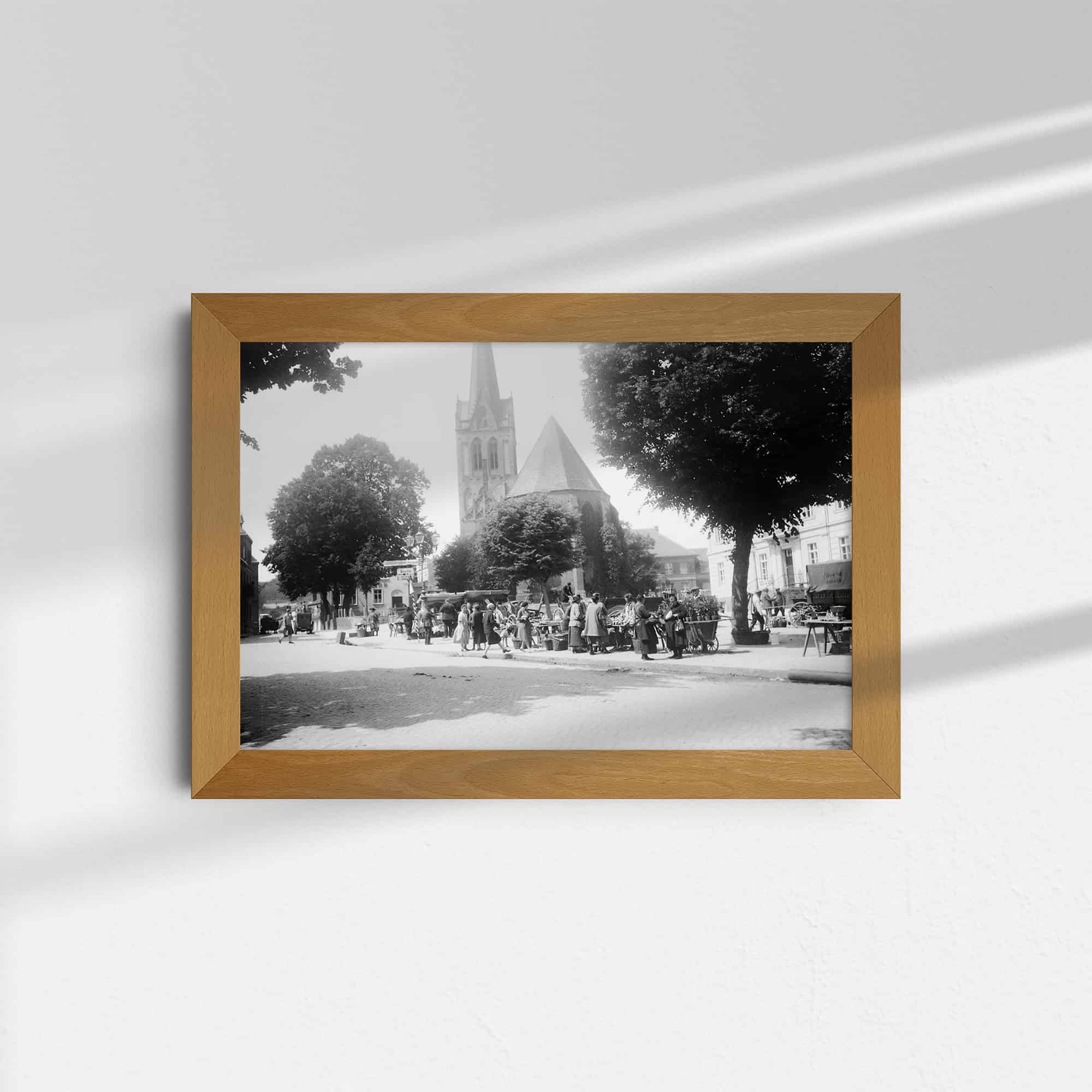 Dieses alte Schwarz-Weiß Foto zeigt einen Platz mit Marktständen und Pferdefuhrwerken in der Stadt Bad Freienwalde (Oder). Rechts ist das Rathaus und im Hintergrund die evangelische Kirche zu sehen. Das Foto wurde um das Jahr 1930 aufgenommen.