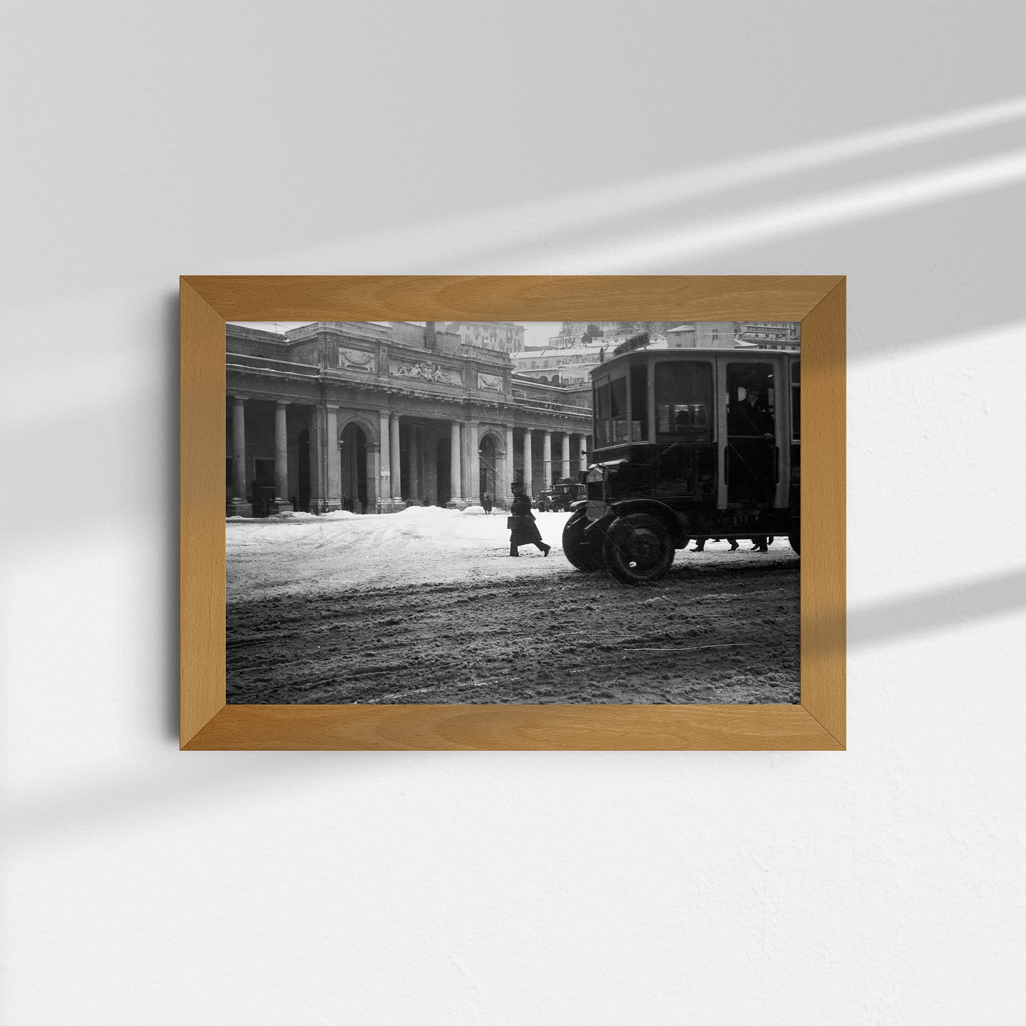 Dieses alte Schwarz-Weiß Foto zeigt eine Szene aus der Stadt Genua in Italien. Im Hintergrund ist der Bahnhof Genova Piazza Principe zu sehen, im Vordergrund ein früher Omnibus. Das Foto wurde um das Jahr 1930 aufgenommen.