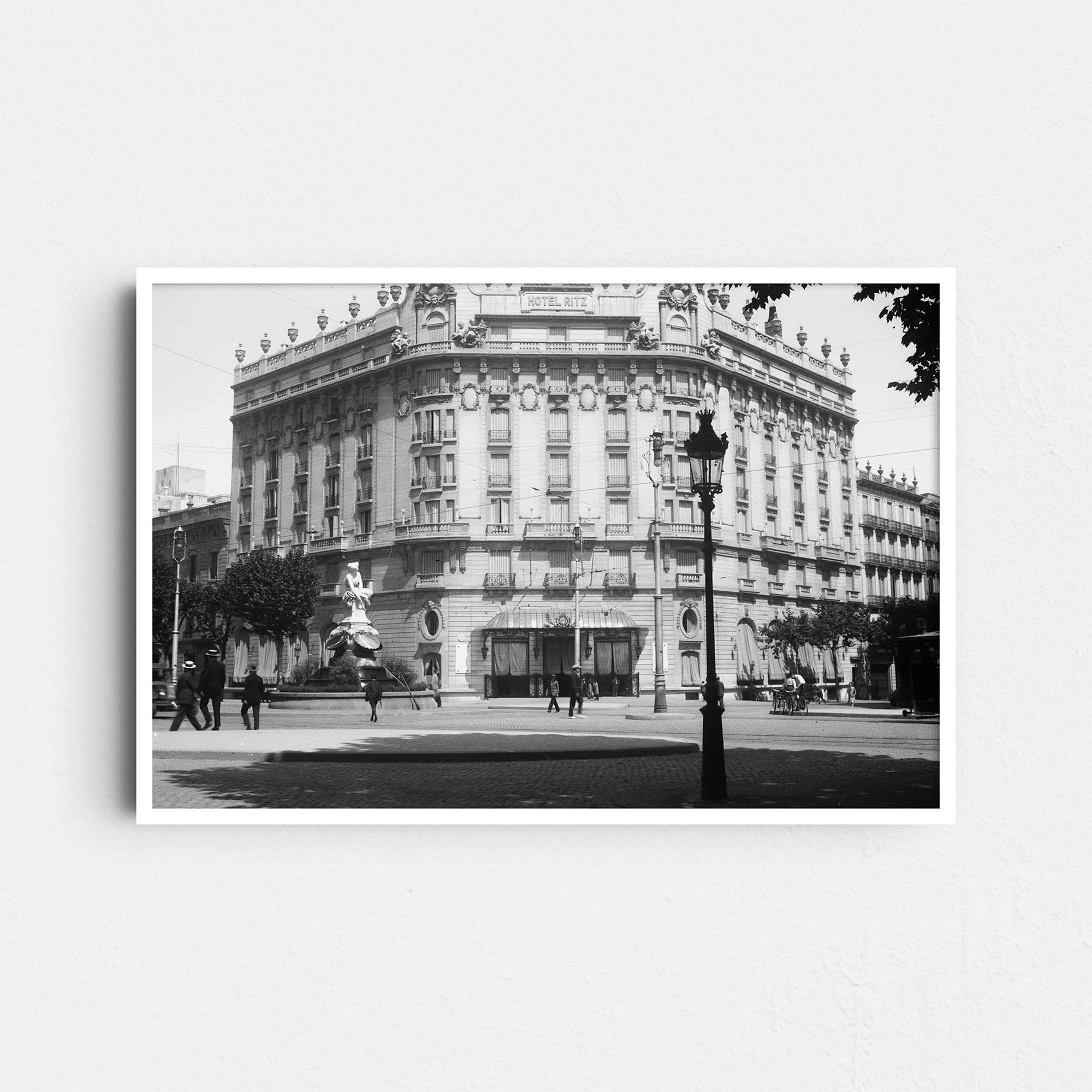 Auf diesem Schwarz-Weiß Foto ist das historische Hotel Ritz in Barcelona zu sehen, das heute als El Palace Barcelona bekannt ist. Es befindet sich an der Ecke Gran Via und Carrer Roger de Llúria. Das Hotel ist ein klassisches Beispiel für den neoklassizistischen Stil mit Belle-Époque-Elementen. Die Fotografie wurde um das Jahr 1930 aufgenommen.