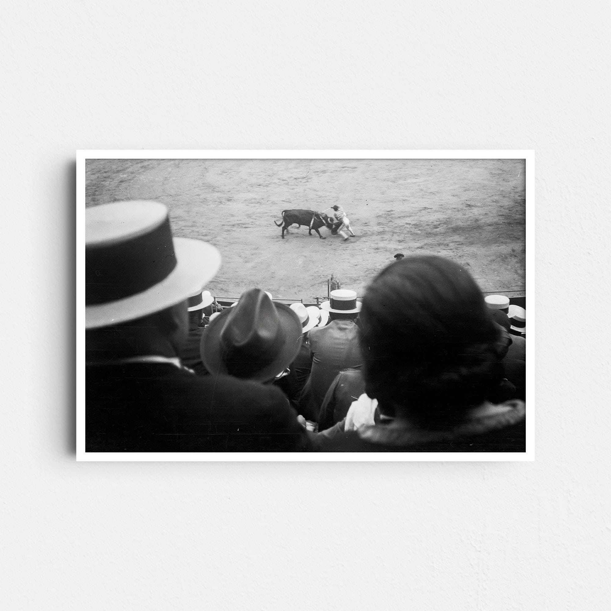 Dieses historische Schwarz-Weiß Foto zeigt einen Stierkampf (Corrida de Toros) in einer vollbesetzten Arena. Das Foto wurde um das Jahr 1930 aufgenommen. Es zeigt Zuschauer in zeitgemäßer Kleidung, die einen Torero beim Kampf mit einem Stier beobachten.