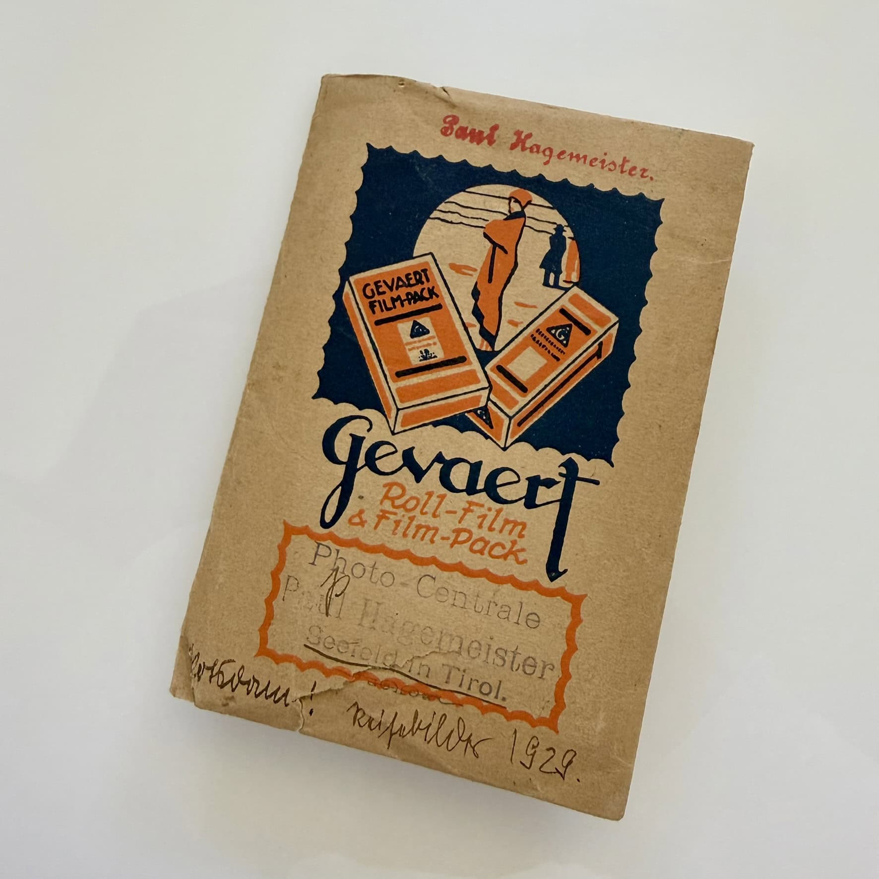 Dieses Foto zeigt ein Kuvert aus Papier, in dem historische Fotos nach dem Entwickeln an Kunden ausgegeben wurden. Das Kuvert ist mit Werbung der Firma Gevaert bedruckt. Zusätzlich ist ein Stempel des Geschäfts zu erkennen, in dem der Film entwickelt wurde: "Photo-Centrale, Paul Hagemeister, Seefeld in Tirol".