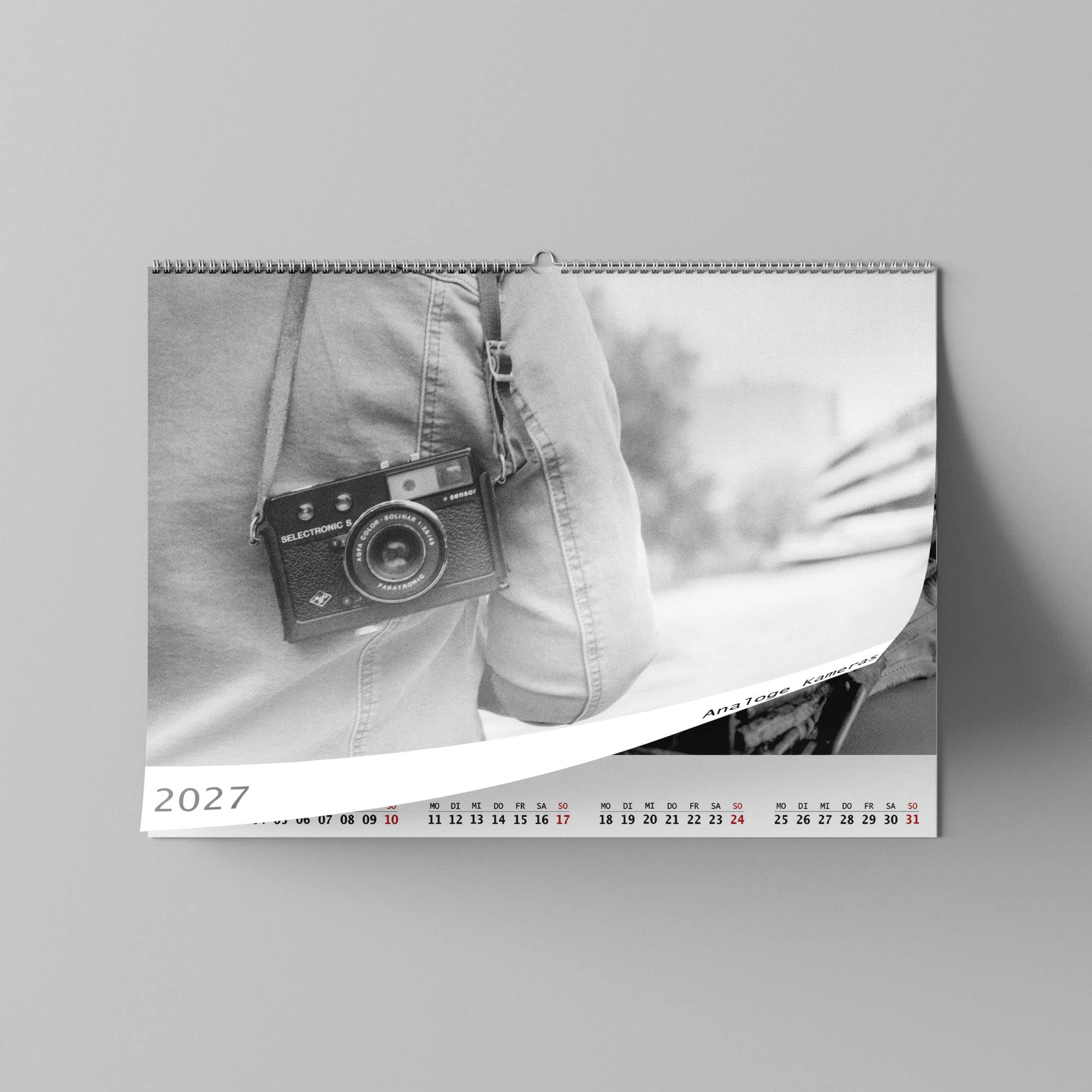Dieses Foto zeigt das Deckblatt eines Fotokalenders 2027 mit schwarz-Weiß Fotos von alten analogen Kameras..
