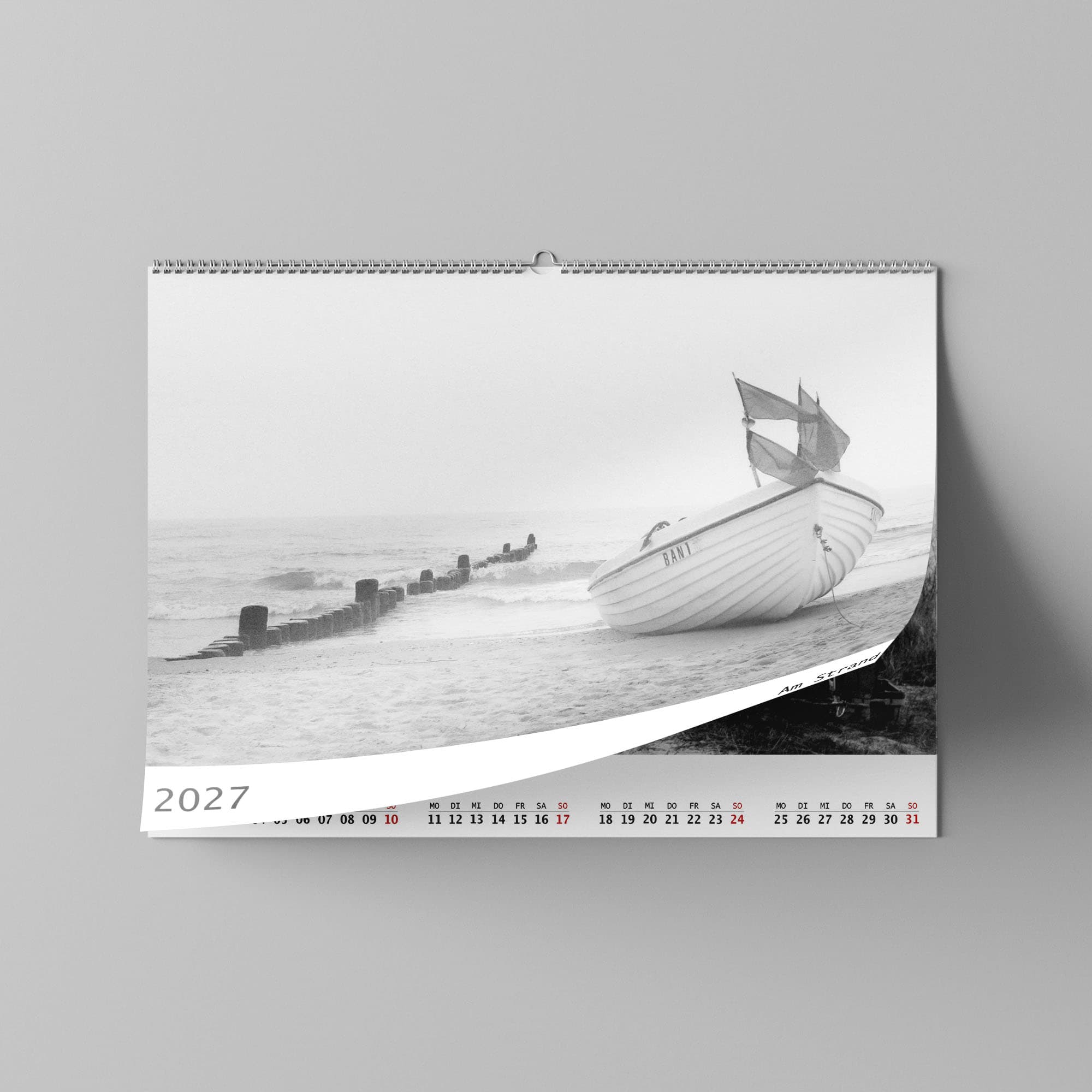 Dieses Foto zeigt das Deckblatt eines Wandkalenders 2027 mit schwarz-Weiß Fotos vom Strand.